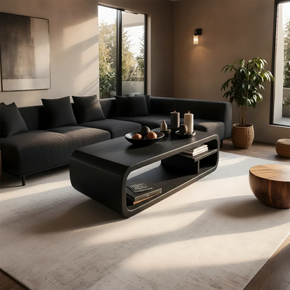 Coffee table in black color with artistic base design and smooth rounded edges in a bright modern space
