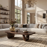 Contemporary coffee table with sleek curves and sturdy pedestal legs in a loft interior