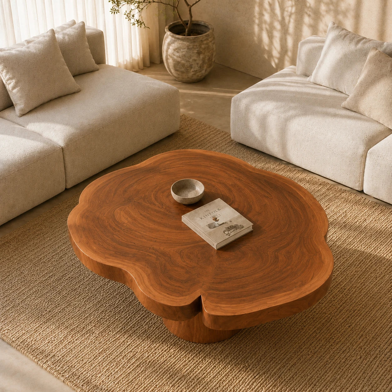 A designer coffee table with a rounded organic top and elegant pedestal support