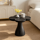 Luxury side table with organic top and sculpted pedestal base in an airy living interior