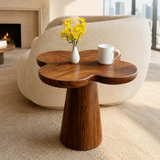 Accent end table featuring a petal shaped top and tapered pedestal base for interiors