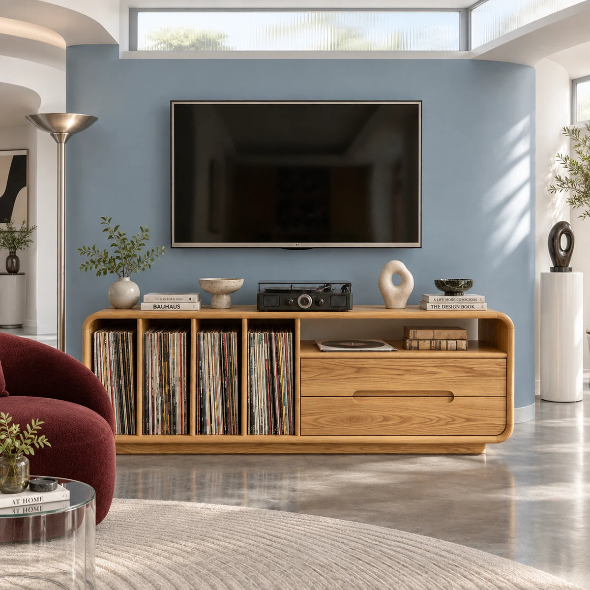 A rounded media cabinet in solid wood with record storage and open display shelf
