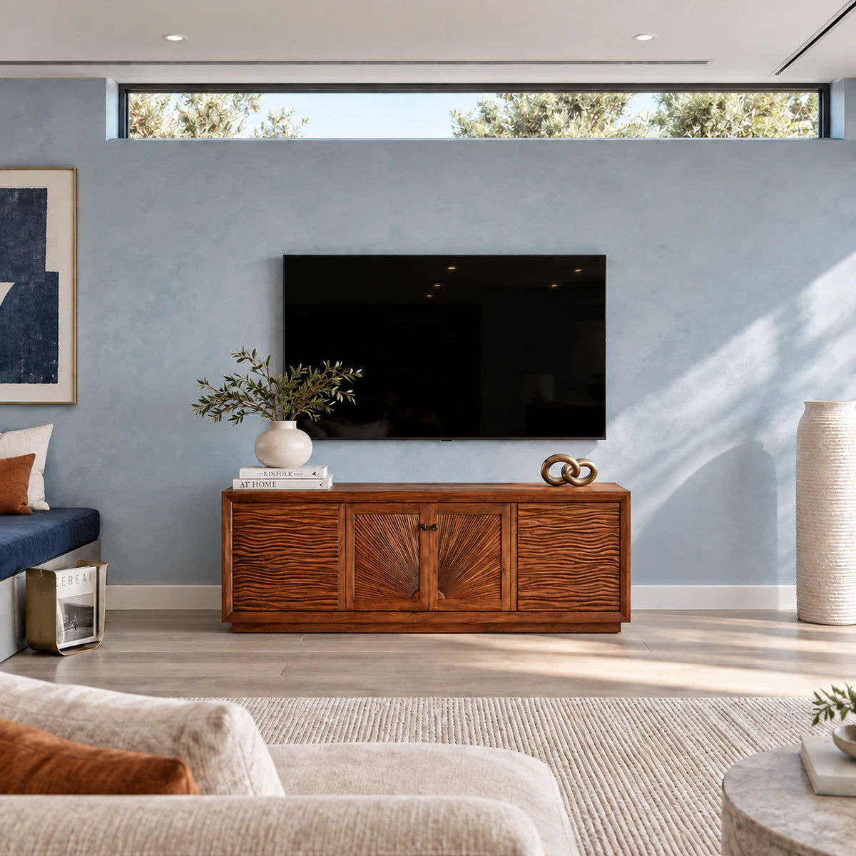 Wide entertainment console in solid wood with sculpted doors and sturdy low base design
