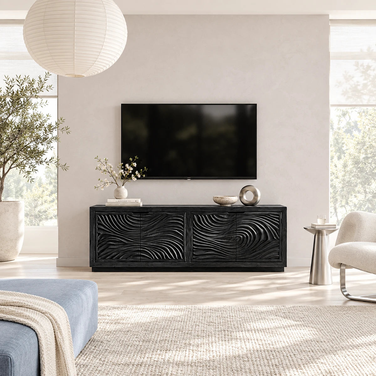 Living room TV console in solid wood with textured carved doors and a clean low stance
