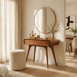 Sculptural makeup vanity with rounded drawer and warm wood tone finish in a bright room