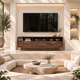 Statement TV stand with flowing carved doors and open shelves beneath a wall mounted TV