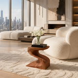 Sculptural end table with an S curve base and warm wood tone finish in a bright room