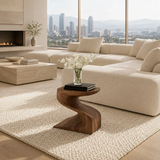 Statement end table with sweeping lines and warm finish in a minimalist home setting