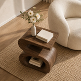 Curved side table adds sculptural character and useful storage to serene living spaces