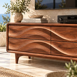 Wide entertainment unit with carved wave details offers concealed storage for media gear