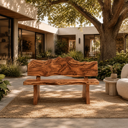 Organic modern bench styled on a woven rug beside a curved chair in an open courtyard