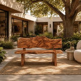 Organic modern bench styled on a woven rug beside a curved chair in an open courtyard