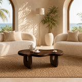 Statement coffee table with an organic edge and warm wood tone finish in cream decor