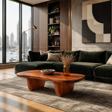 Sculptural coffee table with rounded top and warm wood tone finish in a modern interior