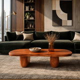 Low profile coffee table with broad surface and warm brown tone finish beside a dark sofa