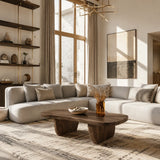 Statement coffee table adds bold rounded form and warm wood tone to an elegant lounge