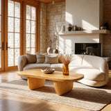 Contemporary coffee table with flowing edges and sturdy sculpted legs in a bright room