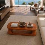Low profile coffee table with oval open base and natural brown wood-tone finish indoors