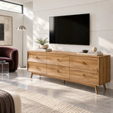 Designer media cabinet in solid wood with six drawers and round brass pull accents
