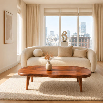 Modern coffee table featuring a flowing top shape and slim tapered solid wood legs