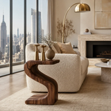 Statement end table with bold flowing lines and visible grain in a minimalist setting