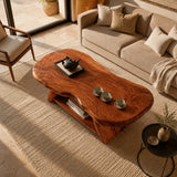 Solid wood coffee table with freeform slab top and practical lower shelf for books