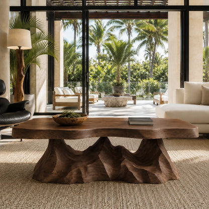 Luxury coffee table with carved pedestal detailing and an artistic natural wood top