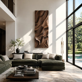 Vertical wall sculpture with flowing carved relief creates depth in a tall modern interior