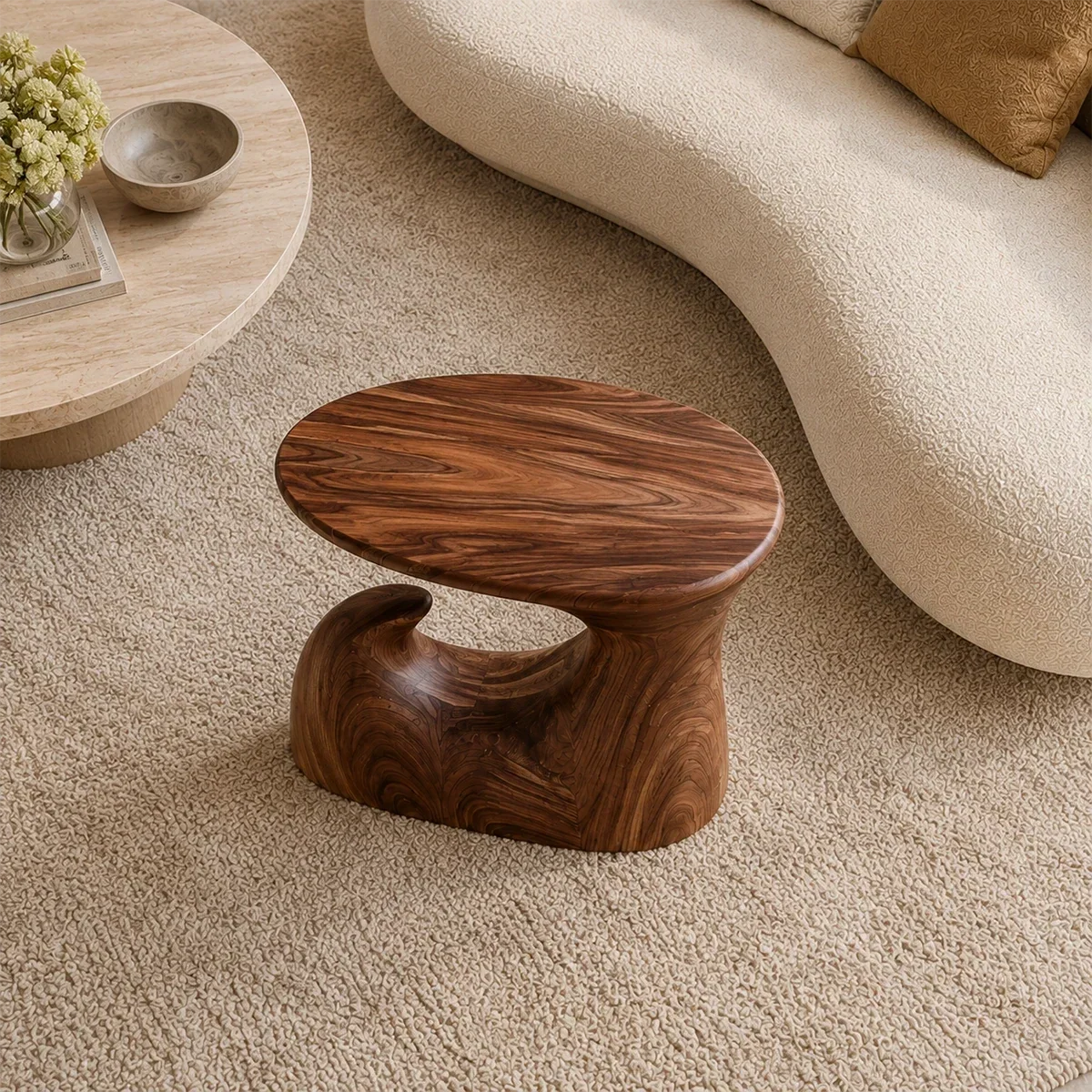 Modern end table with an artistic wave base and warm finish beside lounge seating