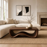 Low profile coffee table with open sculpted base for a calm and elegant lounge setting